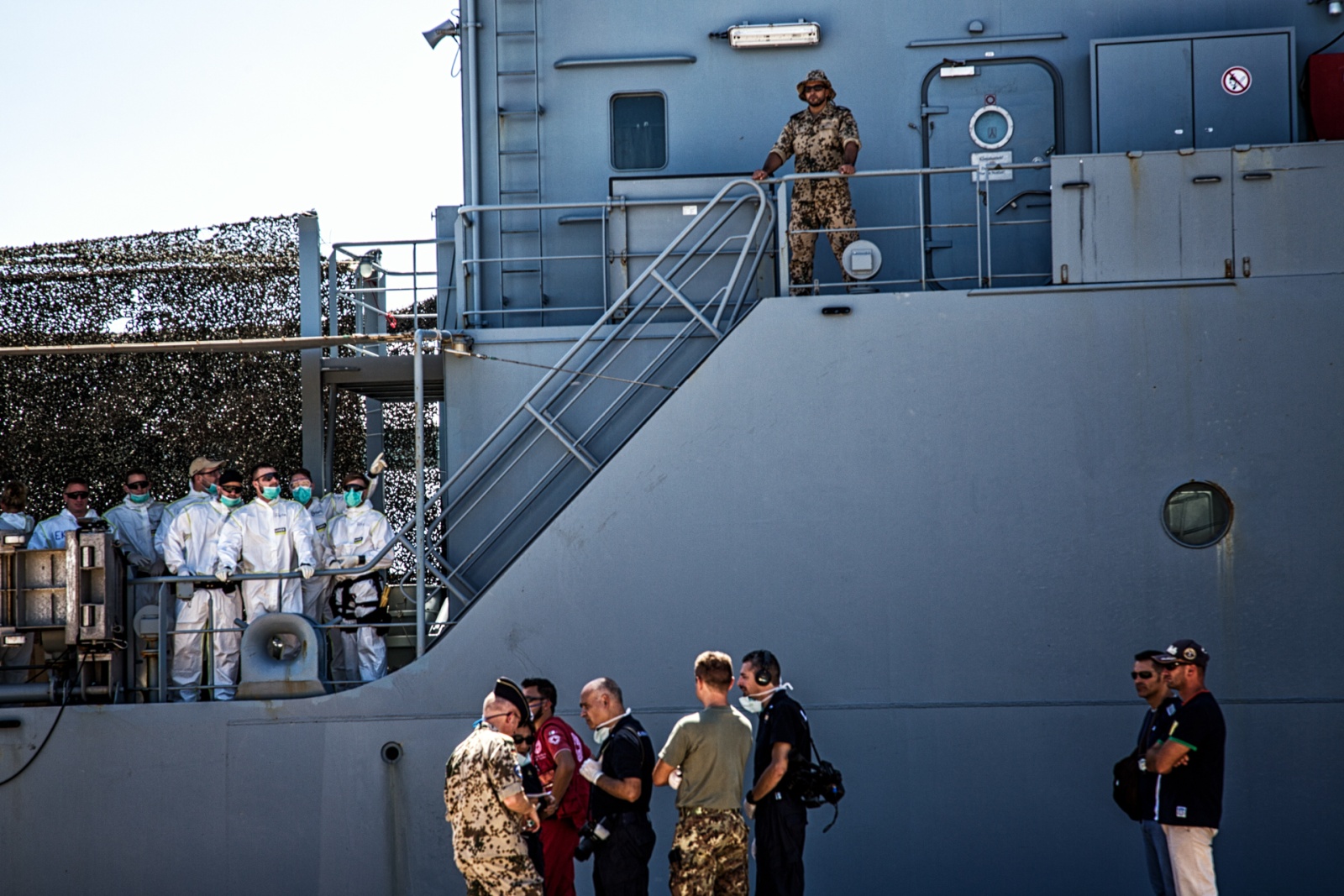 Personale medico e di sicurezza all'arrivo della nave militare tedesca Werra sul molo del porto di Augusta, con 105 migranti recuperati in alto mare il giorno prima agosto 2015. © Max Hirzel.